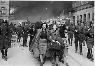 NARA copy #7To the transhipping placeCaptured Jews are led by Waffen SS soldiers to Umschlagplatz. In the back Nowolipie 62 & 63. See file page for possible identity of depicted people.