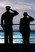 YNSN Jessica Gardner and YNSN Whitney Utter salute as USS&nbsp;Kitty Hawk (CV-63) passes over final resting spot of USS&nbsp;Lexington (CV-2).