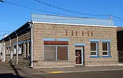 Photograph of a one-story, stone building.