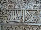 El lema nazarí ("No hay conquistador sino Dios") en caligrafía árabe cursiva, inscrito en el Salón de Embajadores de la Alhambra de Granada (siglo&nbsp;XIV)