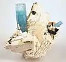 Encajado sobre un feldespato blanco cristalizado aparece un cristal de 4&nbsp;cm de aguamarina