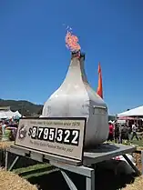 Antorcha con forma de ajo y cartel informativo sobre la recaudación económica