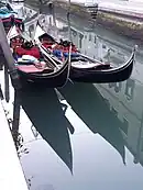 Góndolas de color negro en un canal veneciano