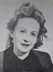 Imagen en blanco y negro de la cabeza de una mujer con pelo más bien corto, tirando a claro y un poco despeinada parece que por el viento. Tiene las cejas muy finas.