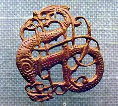 Filigrana vikinga en bronce del siglo&nbsp;XI. La principal aportación de la influencia bárbara al arte altomedieval fue su particular enfoque del problema de la ornamentación, que dejó de ser naturalista para pasar a ser muy geométrica, casi heráldica; motivos trenzados y "en tenaza", la geometrización de motivos anteriores, como las vides pobladas de aves o la misma cruz, desde la cristianización de los bárbaros fueron interpretados de forma totalmente innovadora.