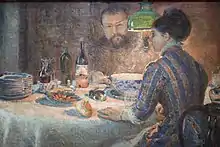 Una mujer y un hombre están comiendo bajo la luz de una lámpara verde