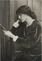 Fotografía de May Morris de perfil, sentada y leyendo