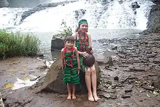 Mujer y joven con trajes tradicionales de la etnia Phnom delante de la cascada  de Bou Sra