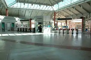 Una entrada vacía de una estación de tren con muchas máquinas expendedoras de billetes situada en una distancia