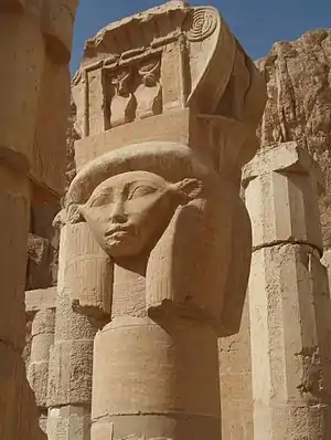 Columna con su cara, coronada por un naos con dos ureos, en el Templo funerario de Hatshepsut, siglo&nbsp;XV&nbsp;a.&nbsp;C.