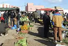 Vendedores particulares en el mercado dominguero, junto a viandantes.