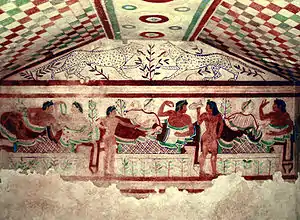 Frescos etruscos de la «tumba de los leopardos» (Tarquinia), donde se representa un simposion, costumbre social de clara influencia griega, representado aquí con el colorido y la concepción festiva propios de la pintura etrusca. Los etruscos desarrollaron una civilización con características orientalizantes dentro del ámbito itálico, del que fueron la potencia dominante hasta que Roma, la capital latina que estuvo sometida a reyes etruscos (Monarquía romana), se terminó imponiendo en los primeros tiempos de la República (del siglo&nbsp;V&nbsp;a.&nbsp;C. al siglo&nbsp;III&nbsp;a.&nbsp;C.).