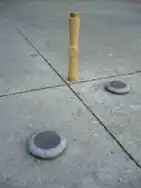 La "tuta" —o "chito"— (con algunas monedas sobre ella y dos grandes doblones o tejos.