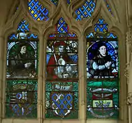 Vitral derecho de la capilla de santa Ana (tercera capilla lateral norte),, de Valentin Bousch (excepto parte derecha del siglo&nbsp;XIX). Los personajes son (de izda. a dcha.): : Fiacre Fériet, notable y comerciante, San Adrian, Jeannon Thiriet, esposa del primero. Por debajo, armas de Lorena, de dnjou y de la ville de Saint-Nicolas.