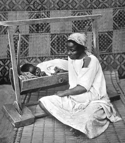 021-A WOMAN OF NORTH AFRICA TENDING TO HER BABY.jpg