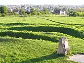 Memorial plaque and trenches covered by grass