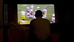 Silhouette of a man in front of a television screen, showing the game