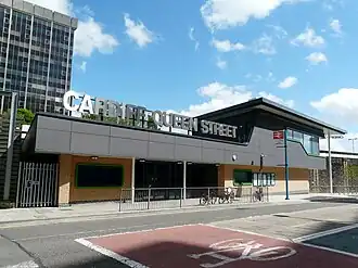 A modern building with lettering made out of reflective material on topː Cardiff Queen Street