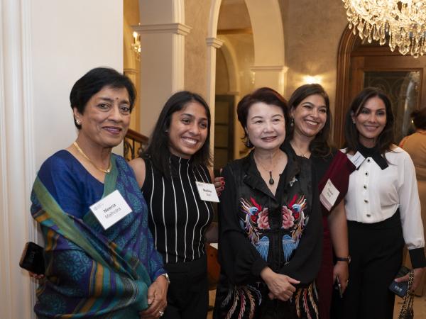 A group of women smiling at the camera in a row.
