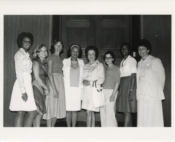 Eight women posing together for a group photo.