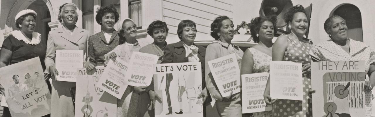 Photograph of women activists with signs for voter registration