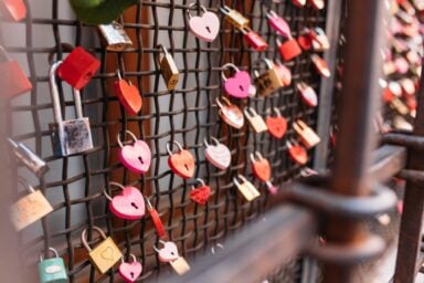 A collection of love locks is displayed on a fence, representing how to be emotionally intelligent in love relationships.